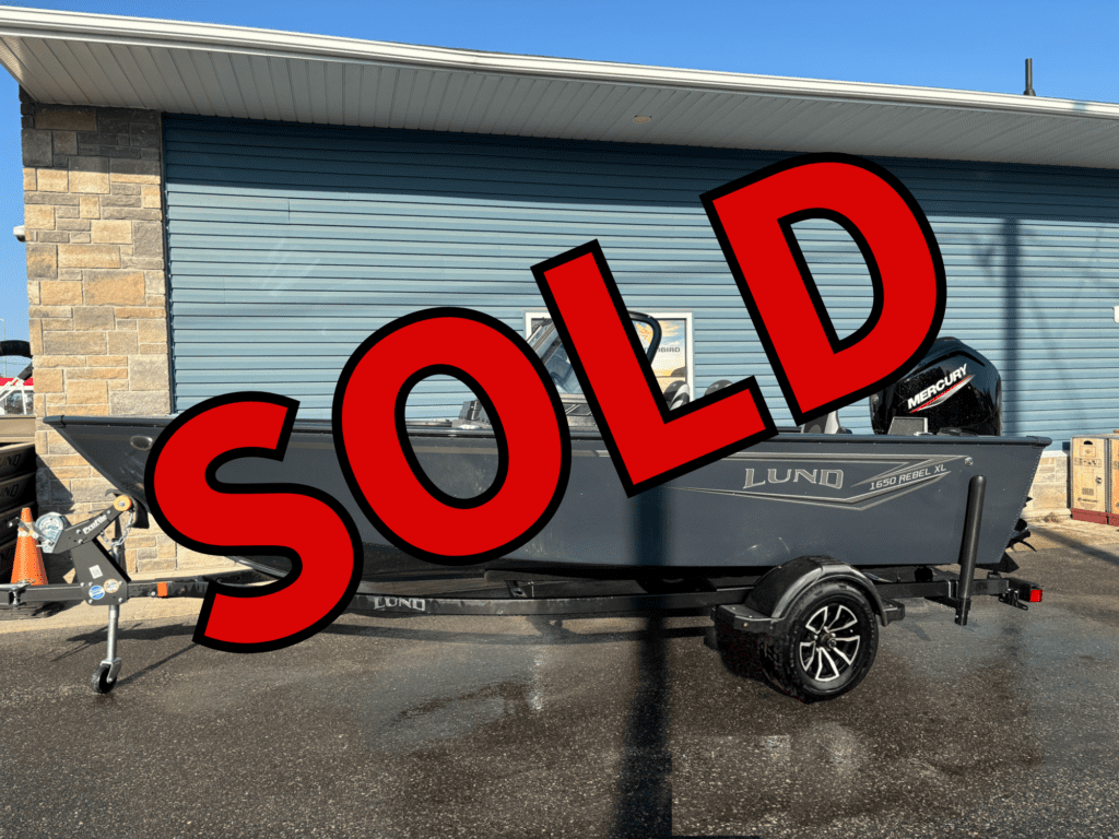 Black pickup truck parked outside a building with a large SOLD sign.