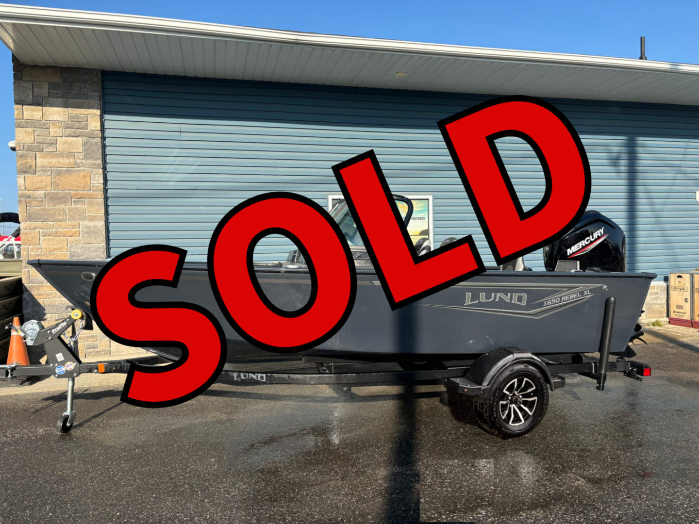 Black pickup truck parked outside a building with a large SOLD sign.