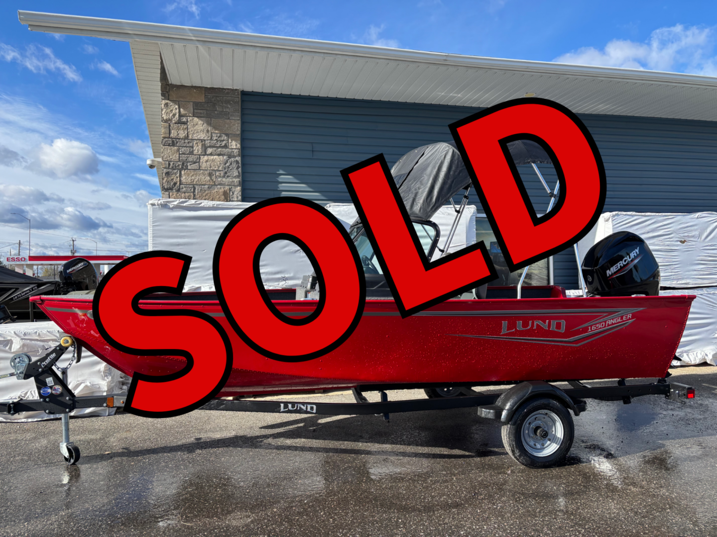 A red boat on a trailer with a large red SOLD text overlay.