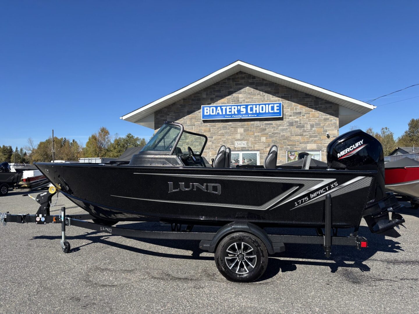 Black Lund fishing boat parked outside a building on a sunny day.
