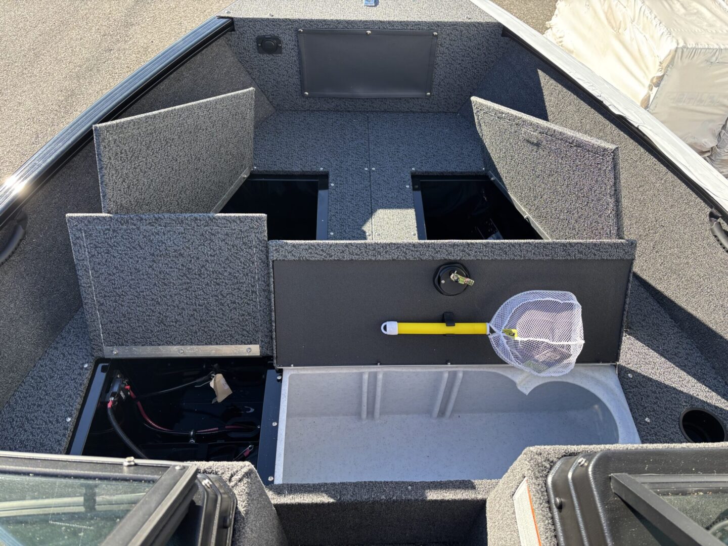 Interior of a fishing boat with carpeted compartments and storage.