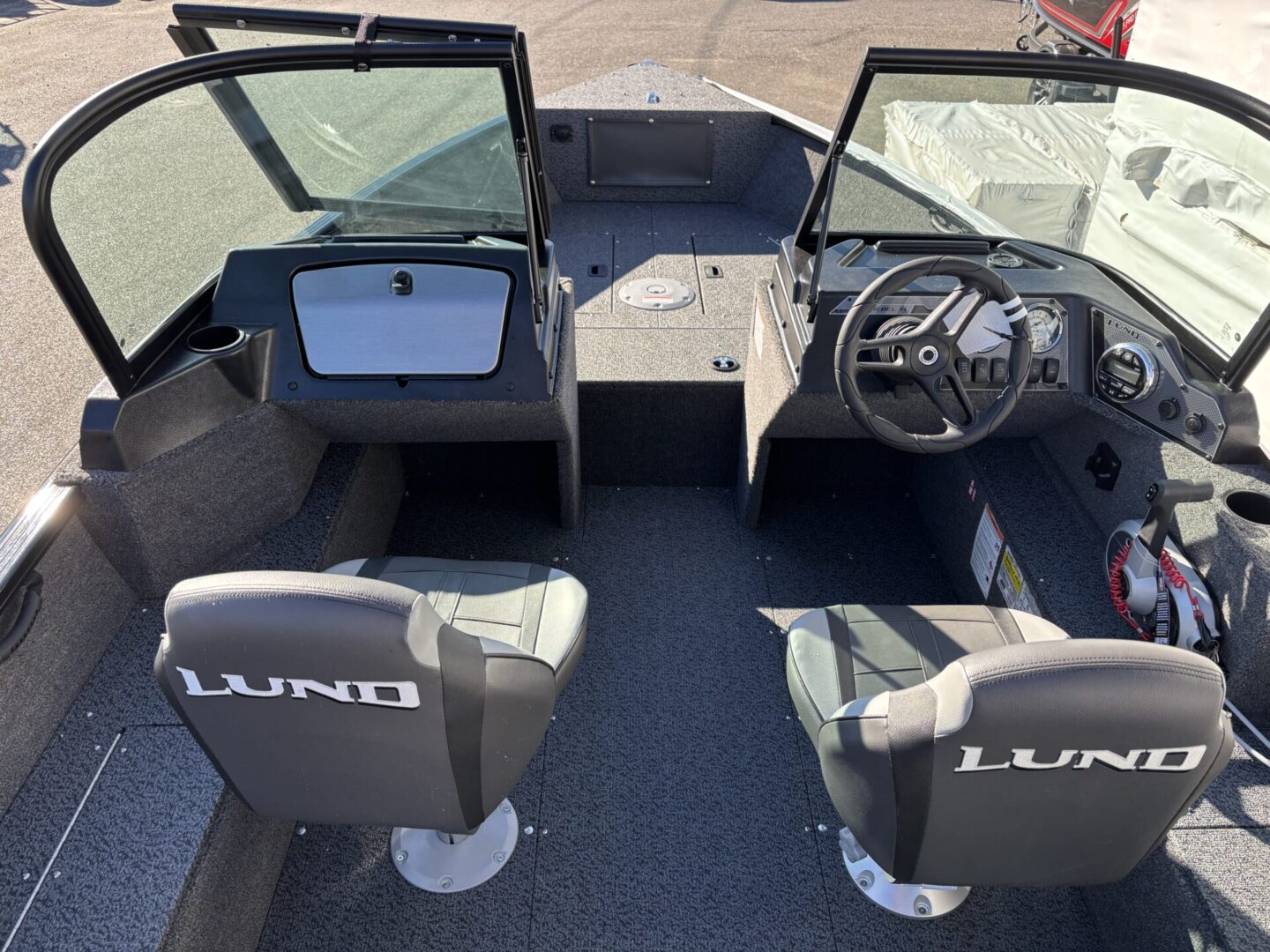 Interior of a Lund fishing boat with two seats and steering console.