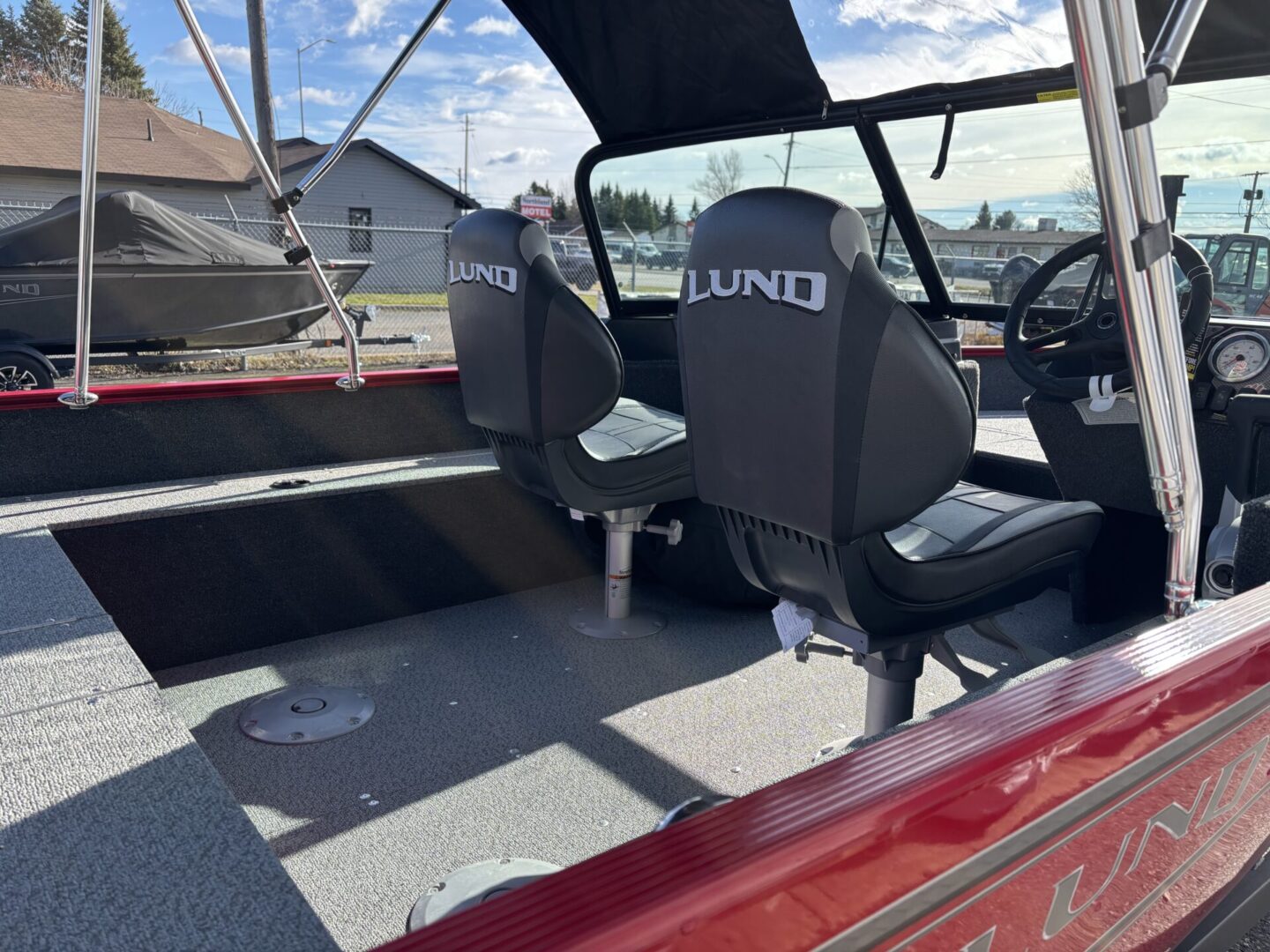 Interior view of a boat with two seats and a steering wheel.