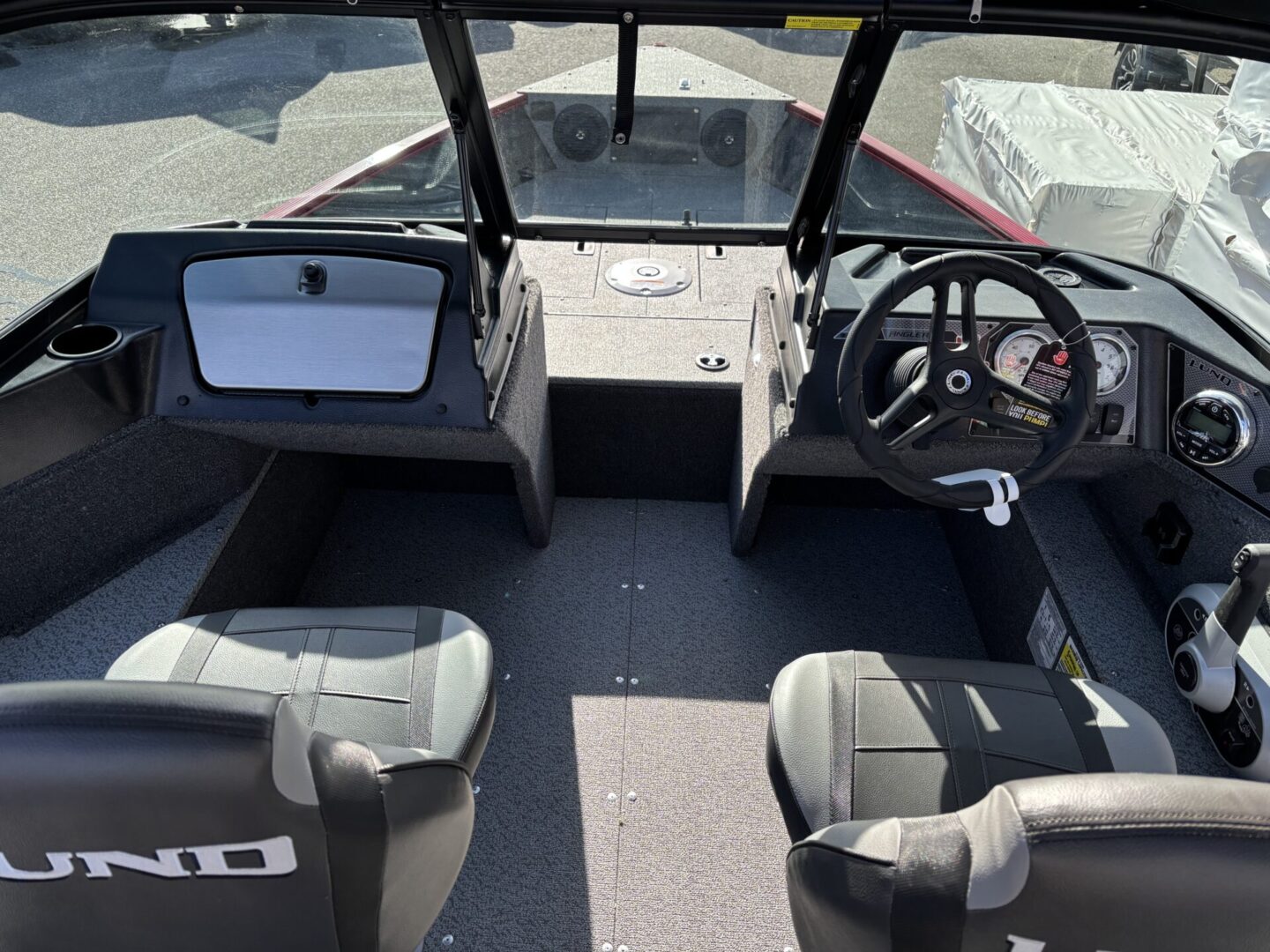 Interior of a modern boat with two seats and a steering wheel.