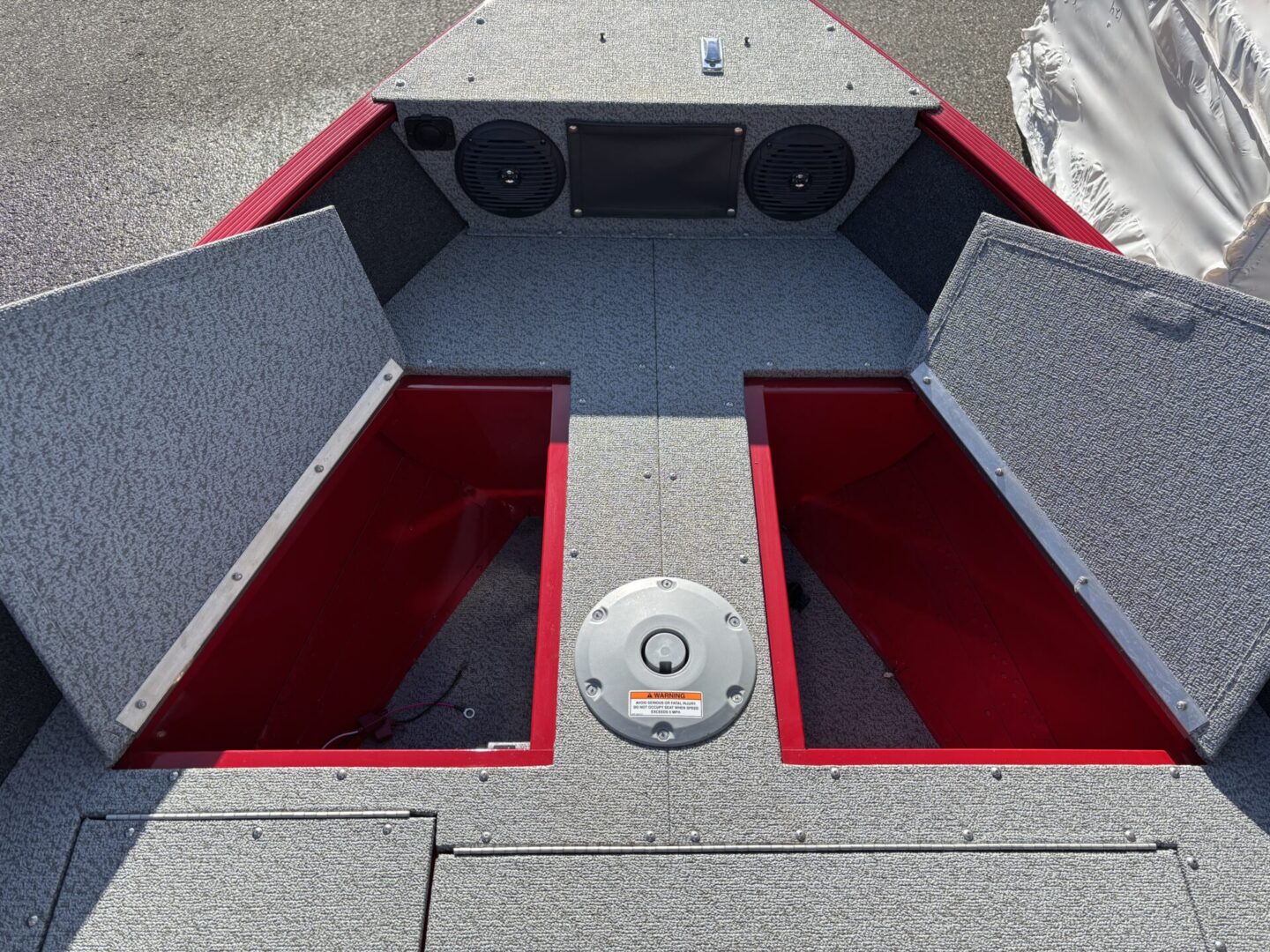 Open compartments on a red and gray boat deck.