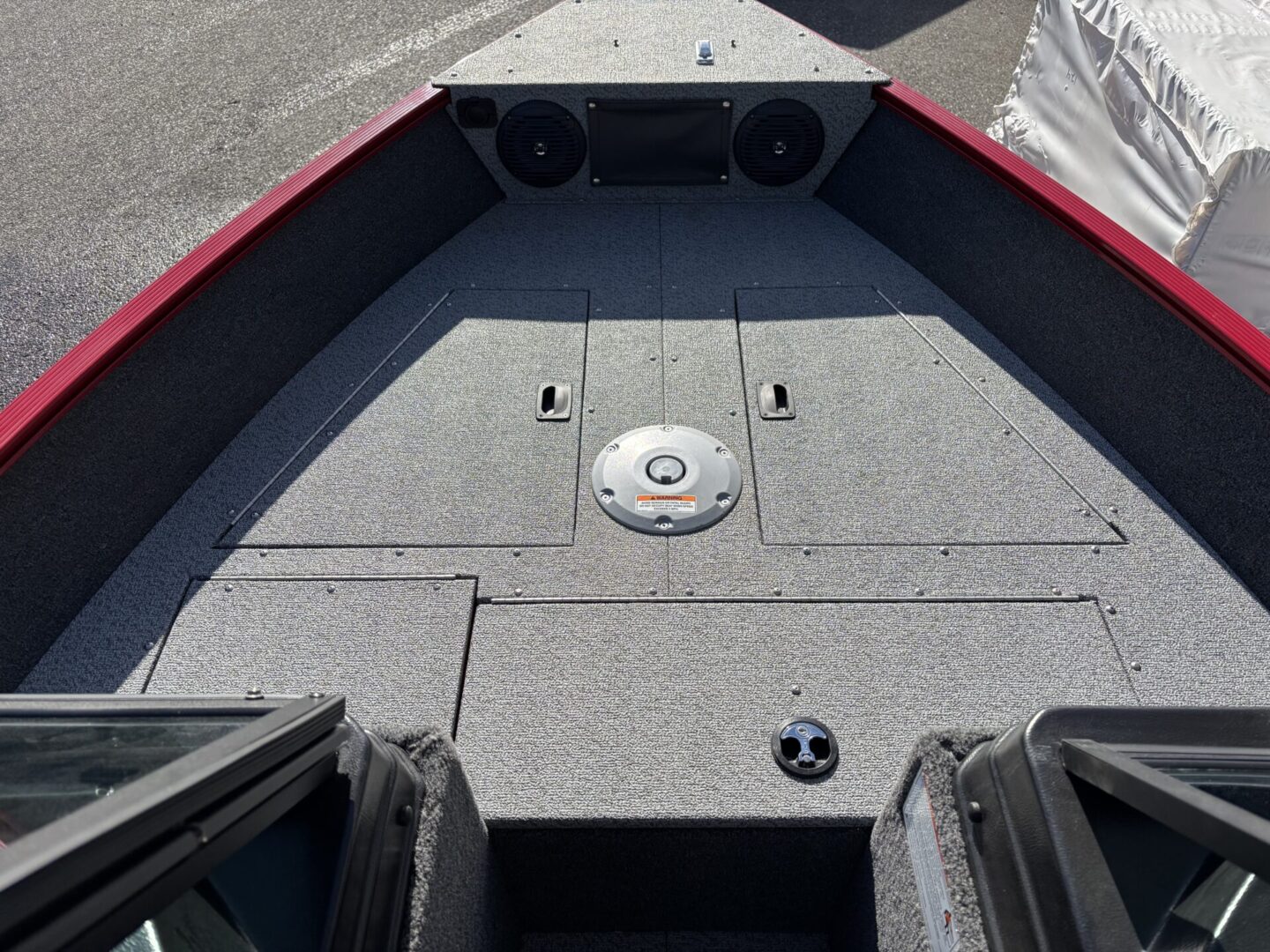 Carpeted boat deck with built-in speakers and compartments.