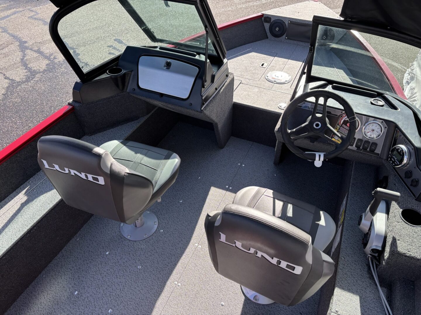 Cockpit view of a fishing boat with swivel seats and a mounted fish finder.