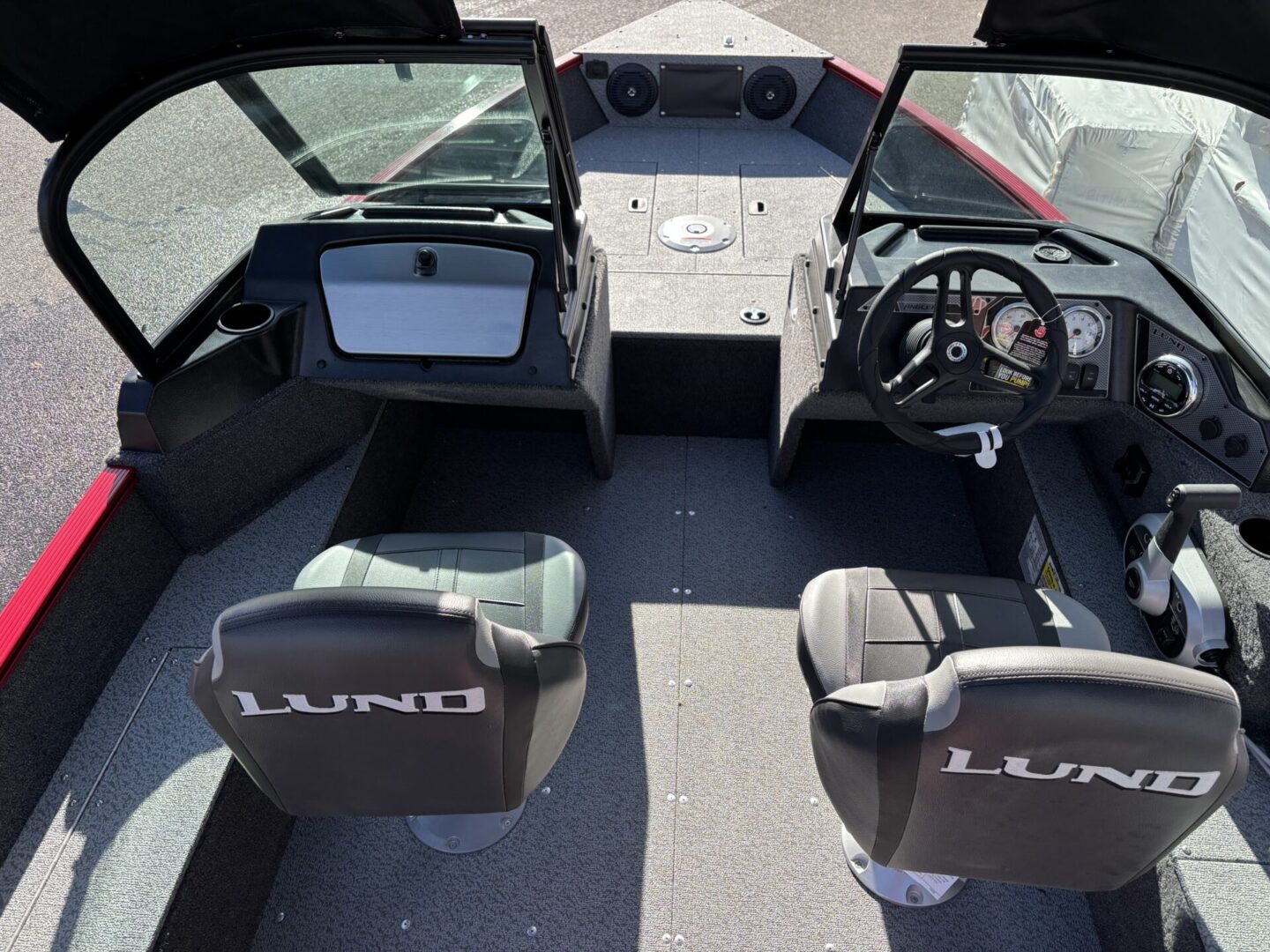 Interior view of a Lund boat with two seats and steering wheel.
