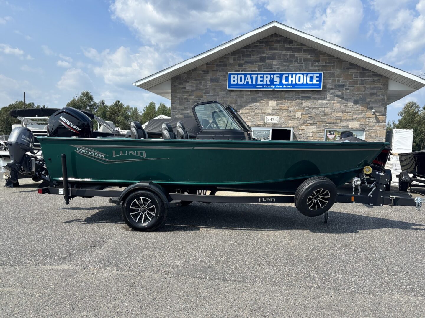 Green fishing boat with trailer parked outside Boater's Choice.