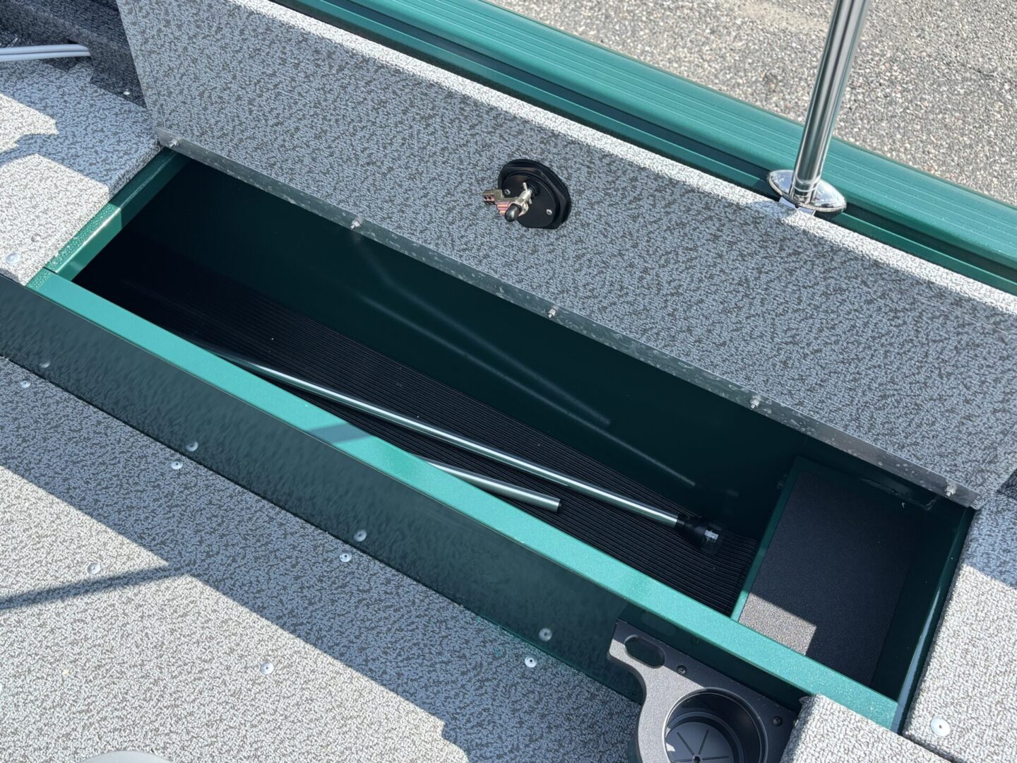 Open boat storage compartment with a paddle inside.