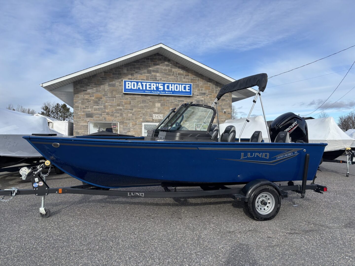 Blue fishing boat parked outside a building labeled 'Boater's Choice'.