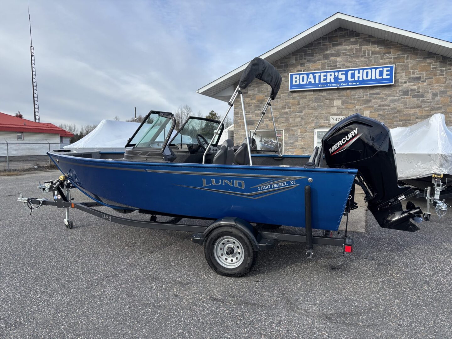 Blue aluminum fishing boat on trailer in front of Boater's Choice store.
