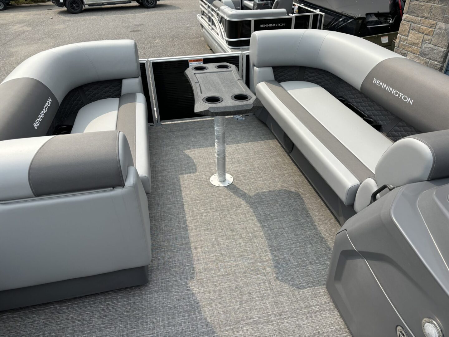 Spacious boat seating with a central table and cup holders on a carpeted deck.