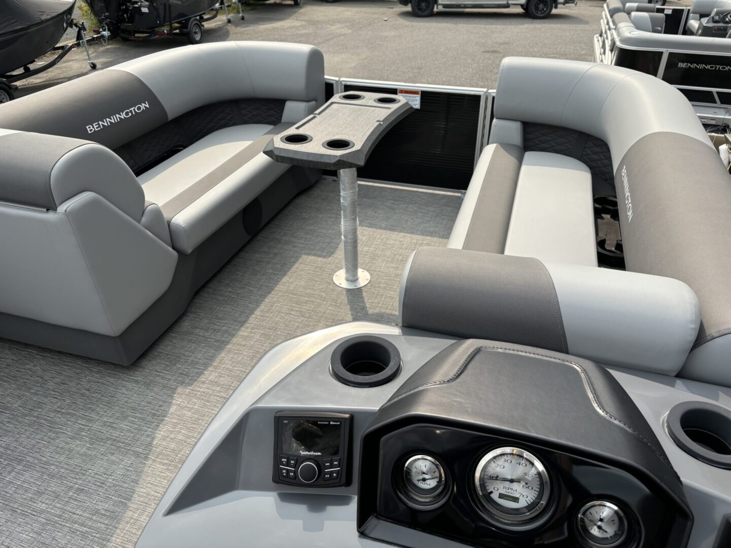 Modern gray boat seating with cup holders and control panel.