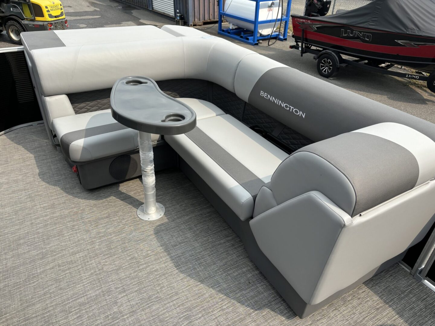 Modern gray and black L-shaped sofa with a small table on a carpeted floor.