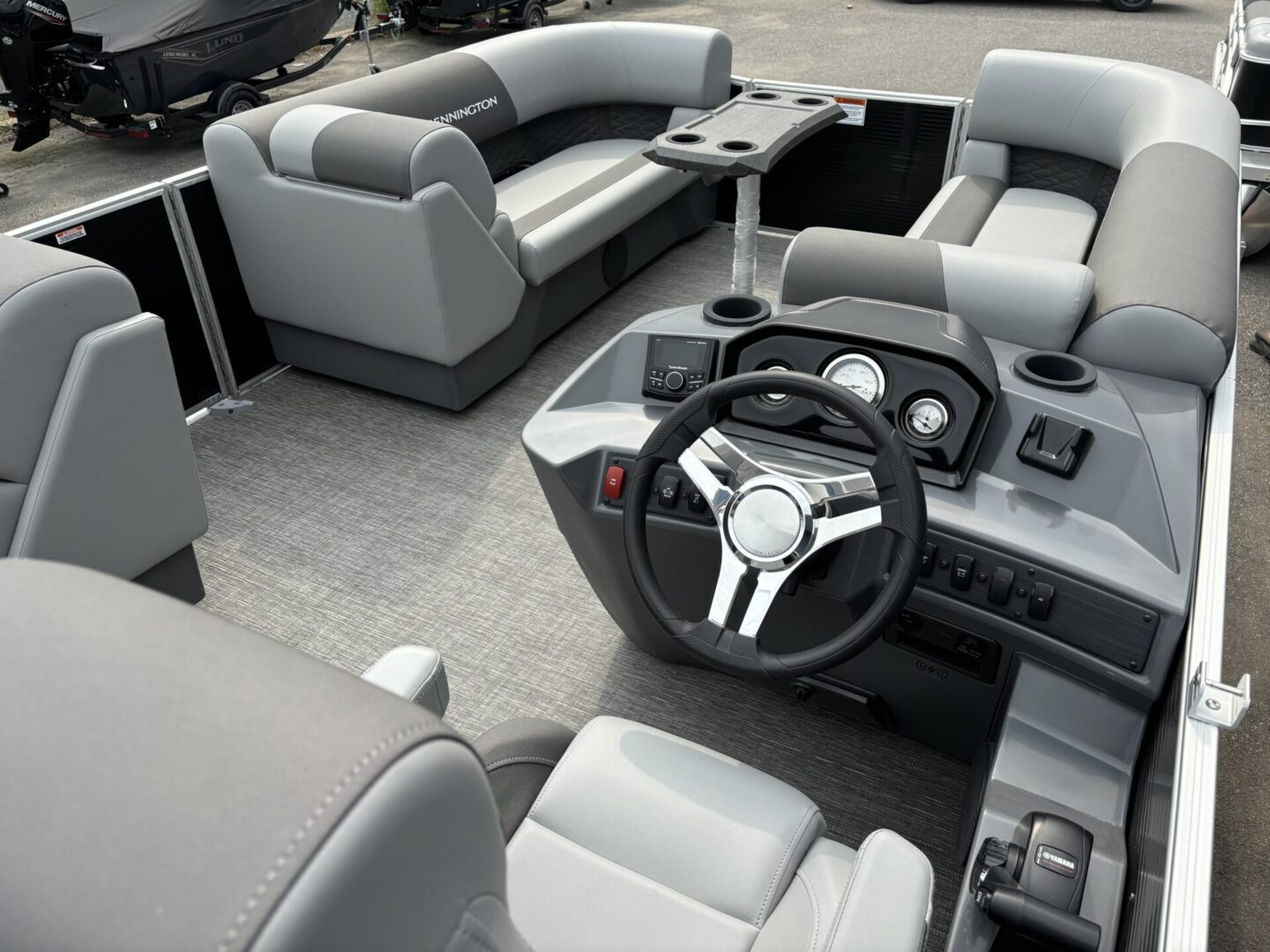Modern boat interior with gray seating and steering console.