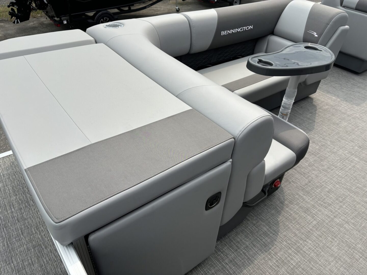 Modern boat seating with gray cushions and a small round table.