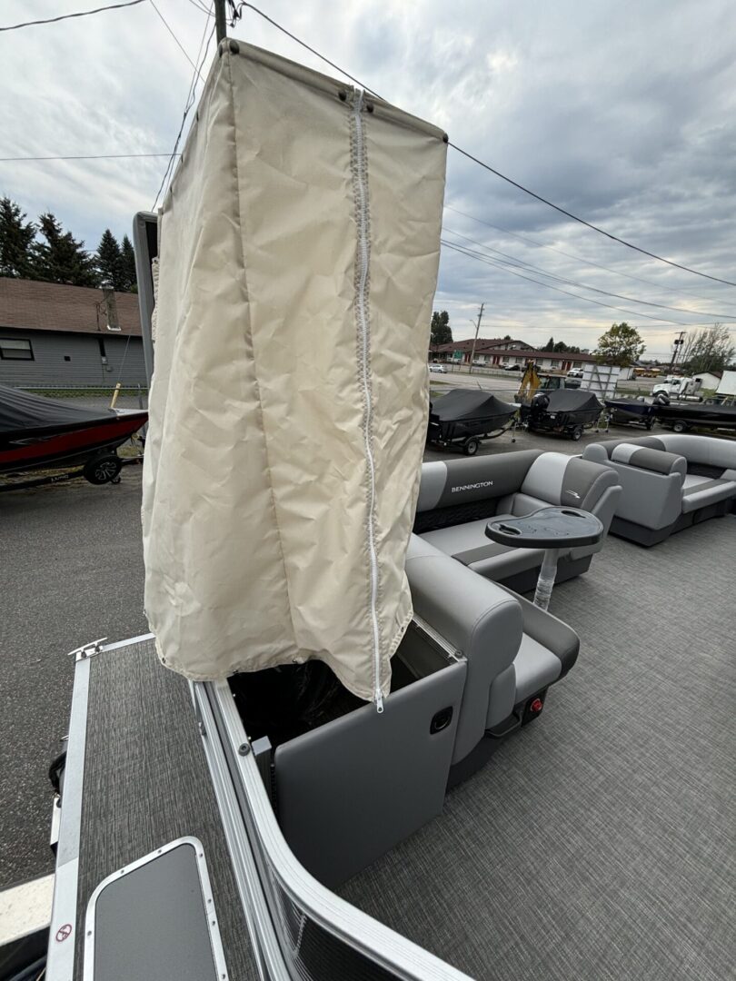 Boat with a covered sail and seating area on deck.