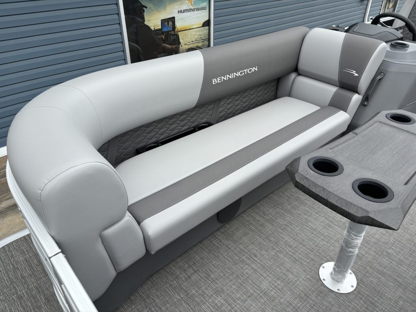 Spacious gray and white boat seating with cup holders and textured floor.