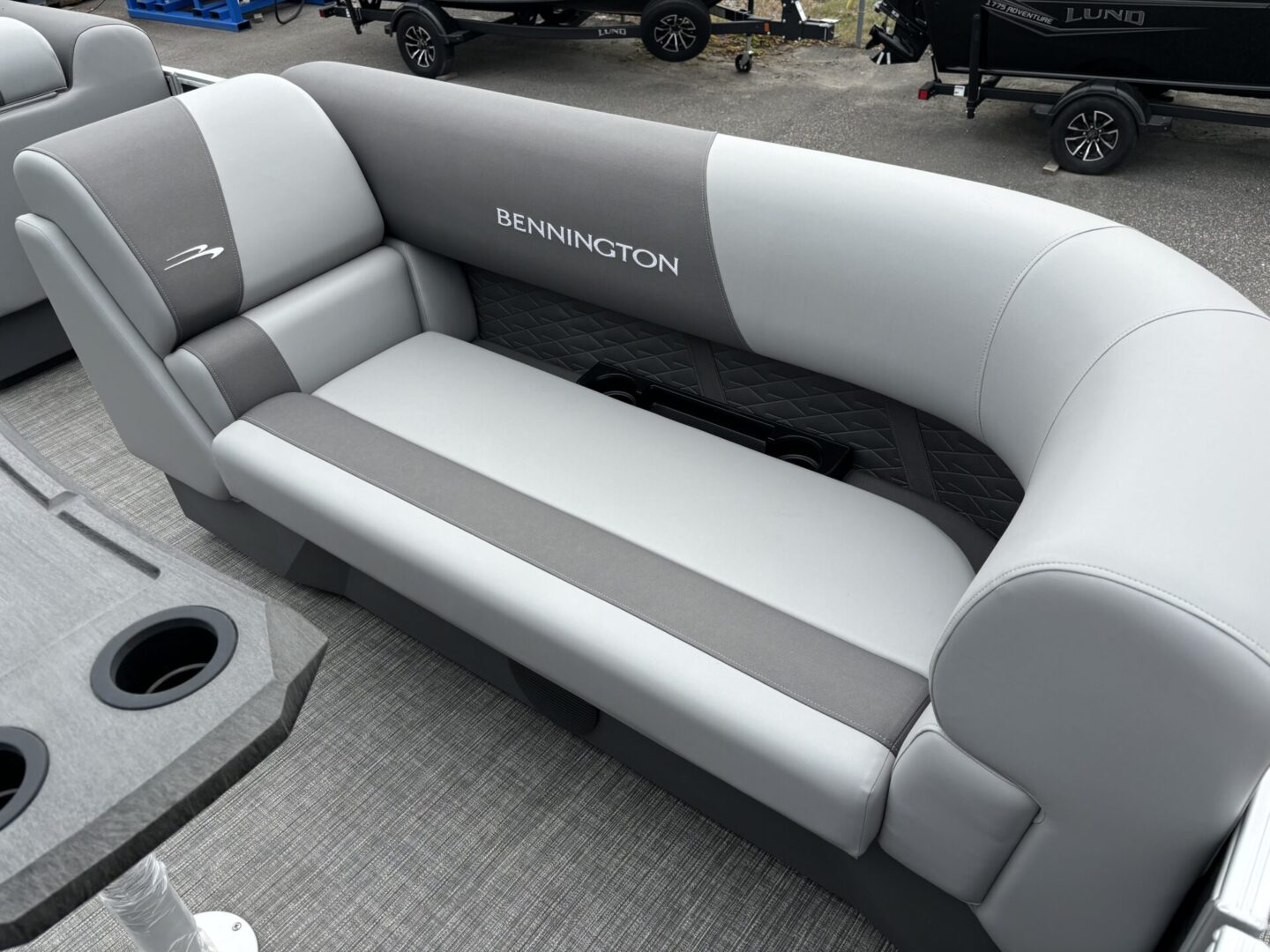 Gray and white cushioned boat seating with cup holder.