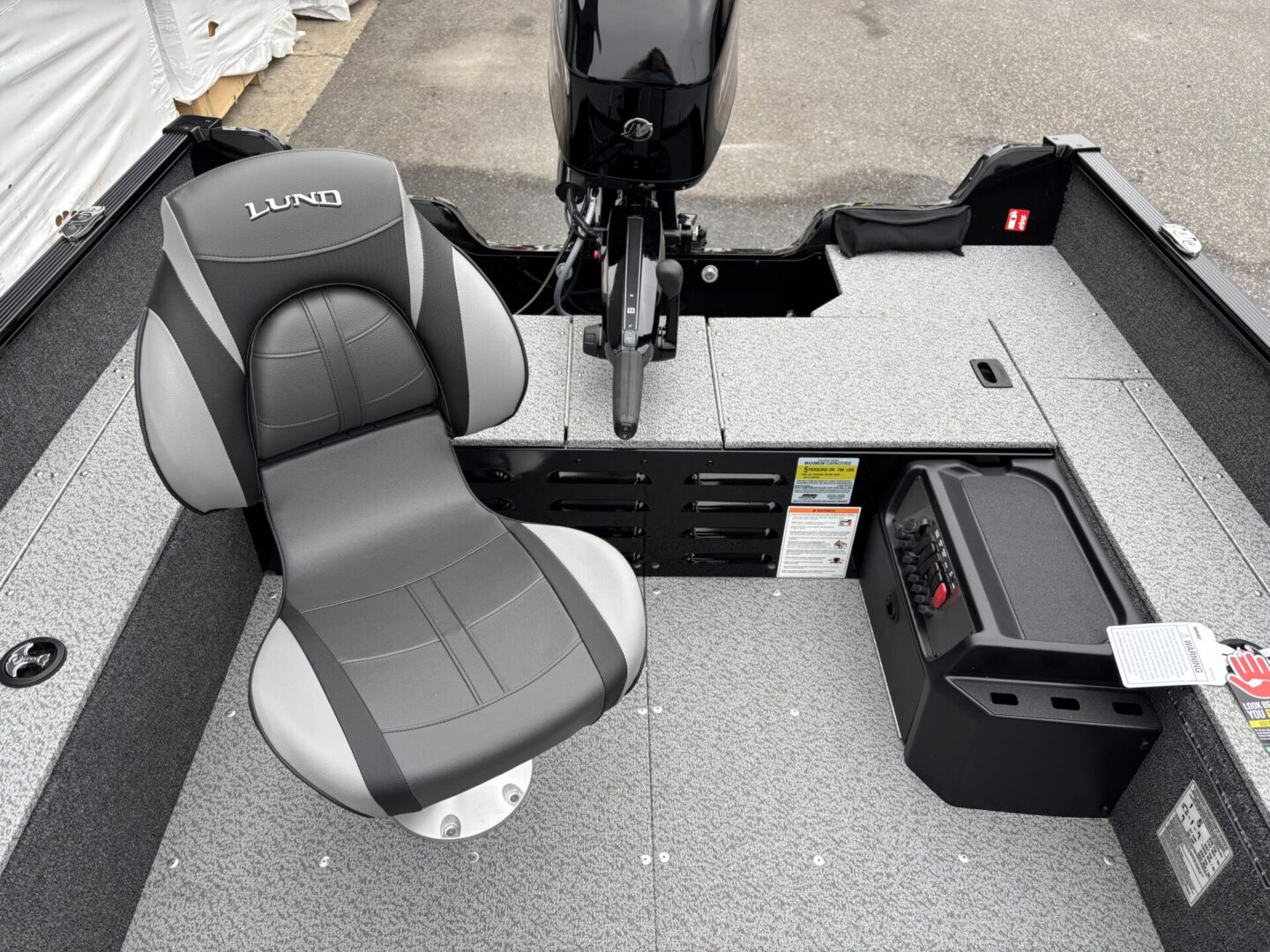 Boat captain's seat with fishing rod holders and storage compartments.