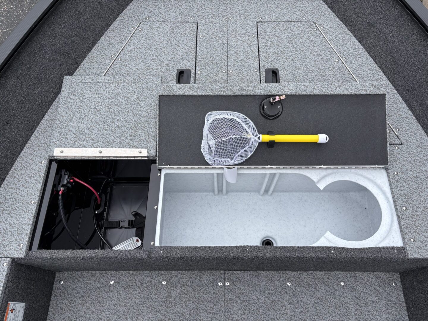 Open compartment showing fishing equipment and storage space on a boat.