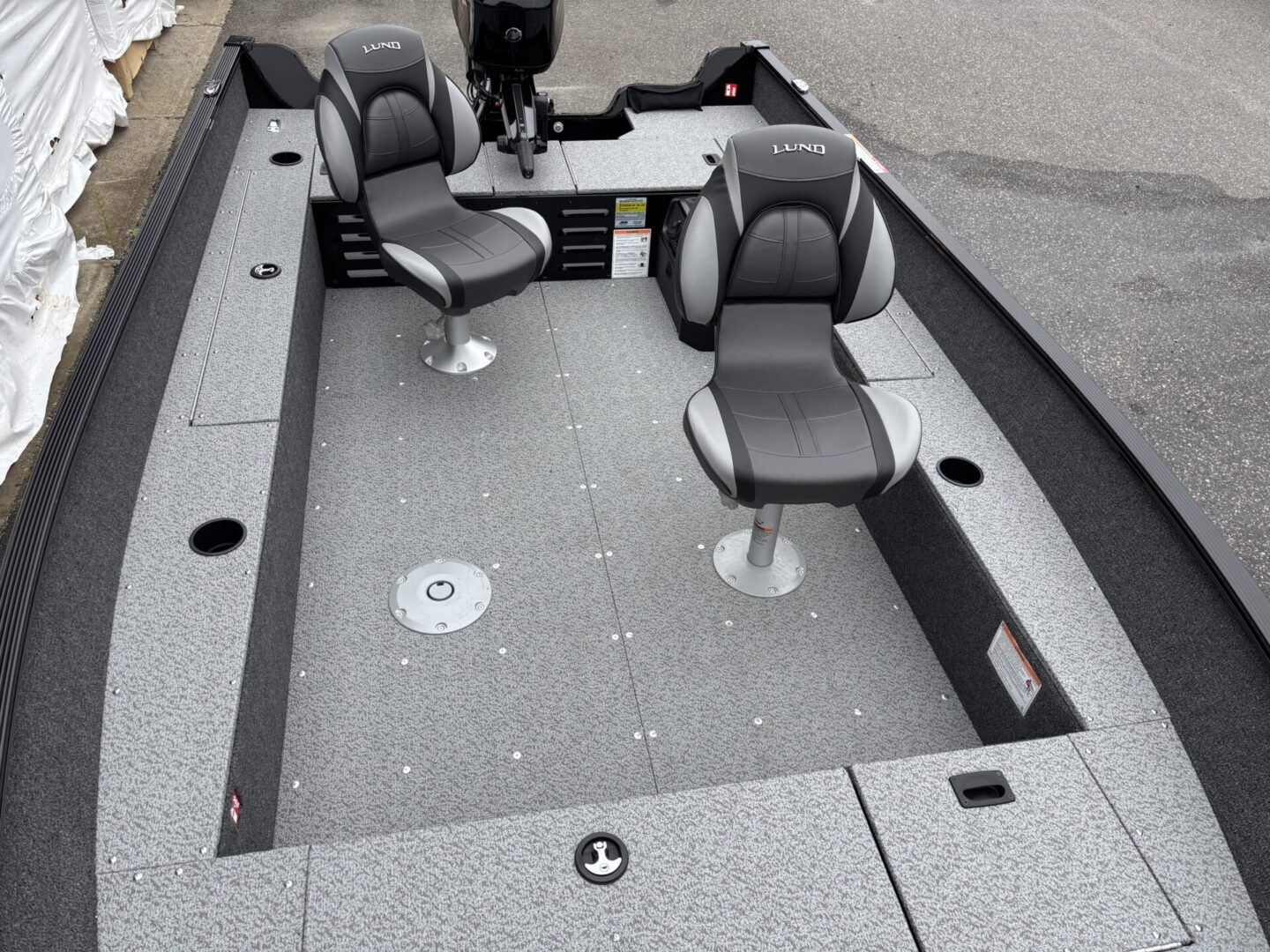 Interior view of a fishing boat with two padded swivel seats.