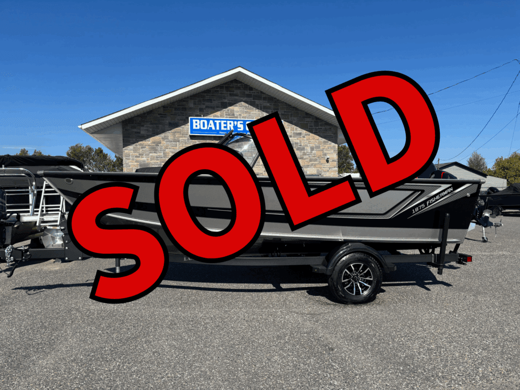 A black boat on a trailer in front of a building with a 'SOLD' text overlay.