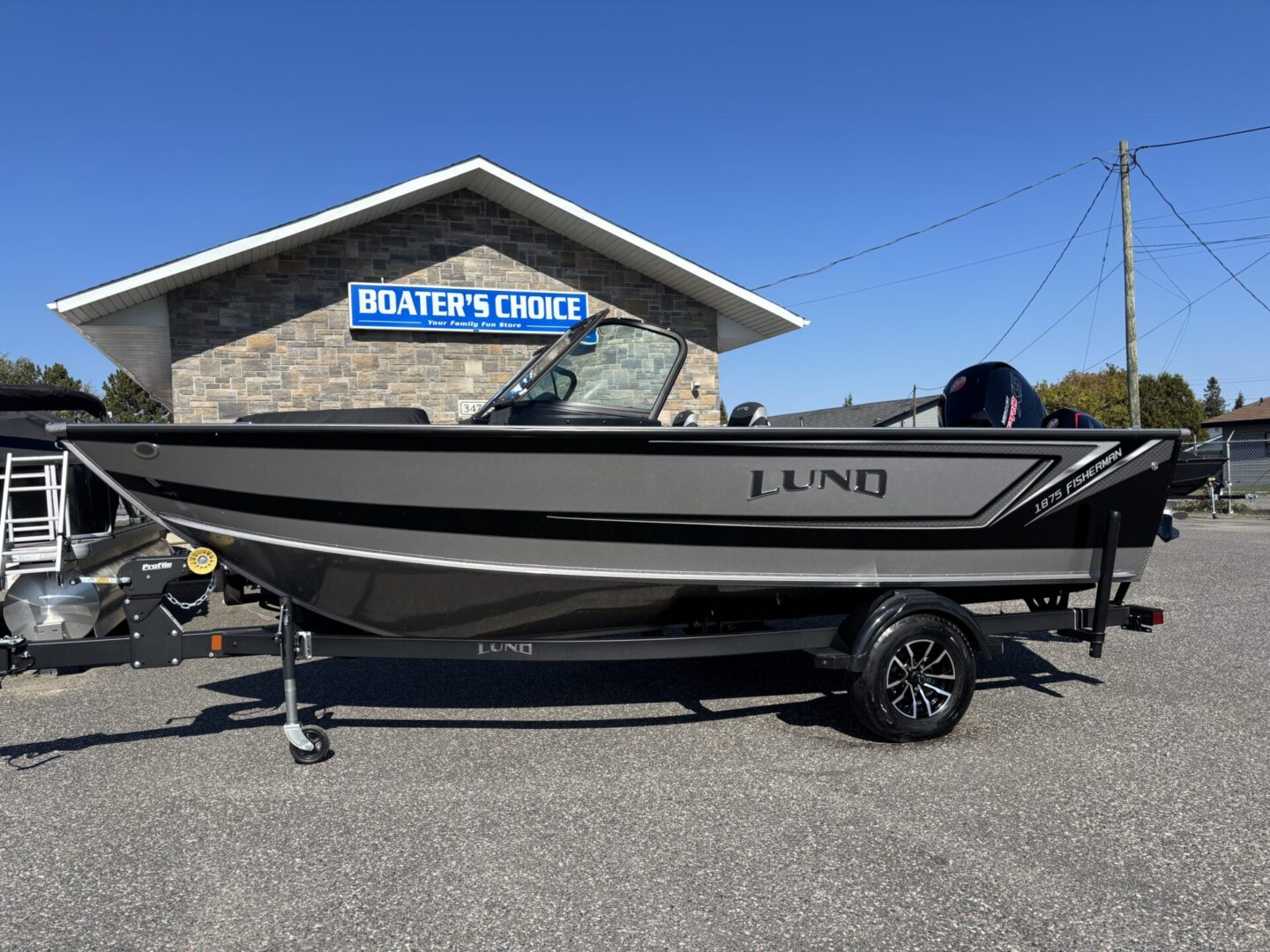 A sleek Lund fishing boat on a trailer outside Water's Edge.