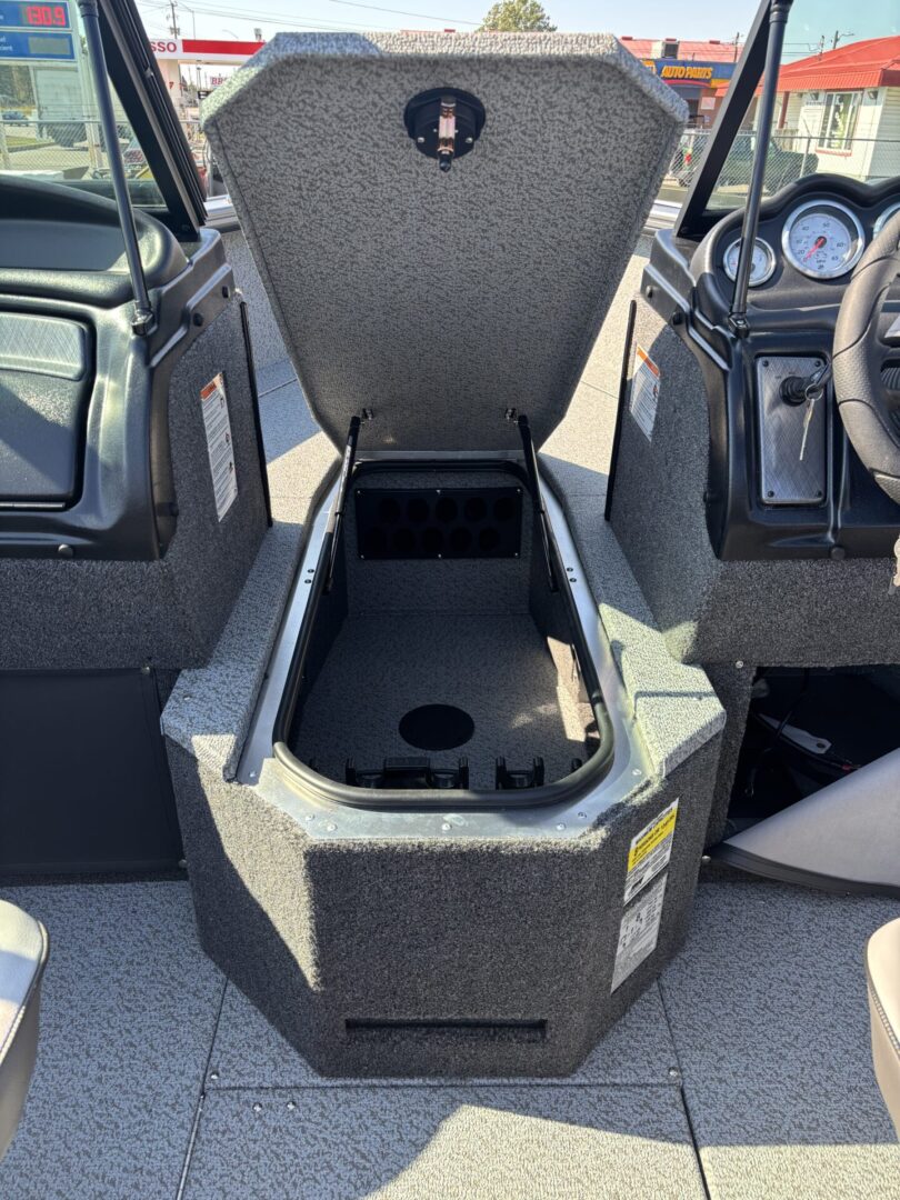 Open storage compartment in a boat with cup holders inside.