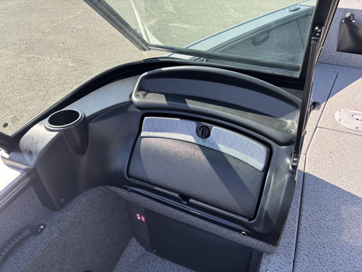 Interior view of a boat's cockpit area with storage compartment.