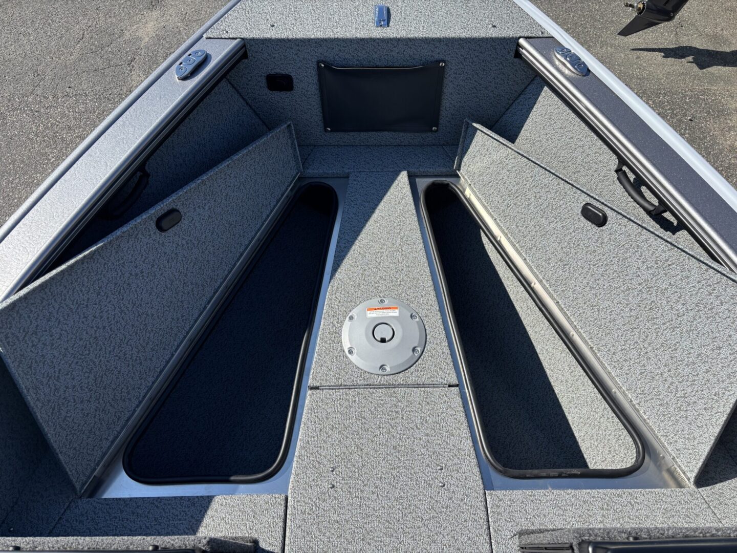 Open storage compartments on a boat deck revealing spacious interiors.