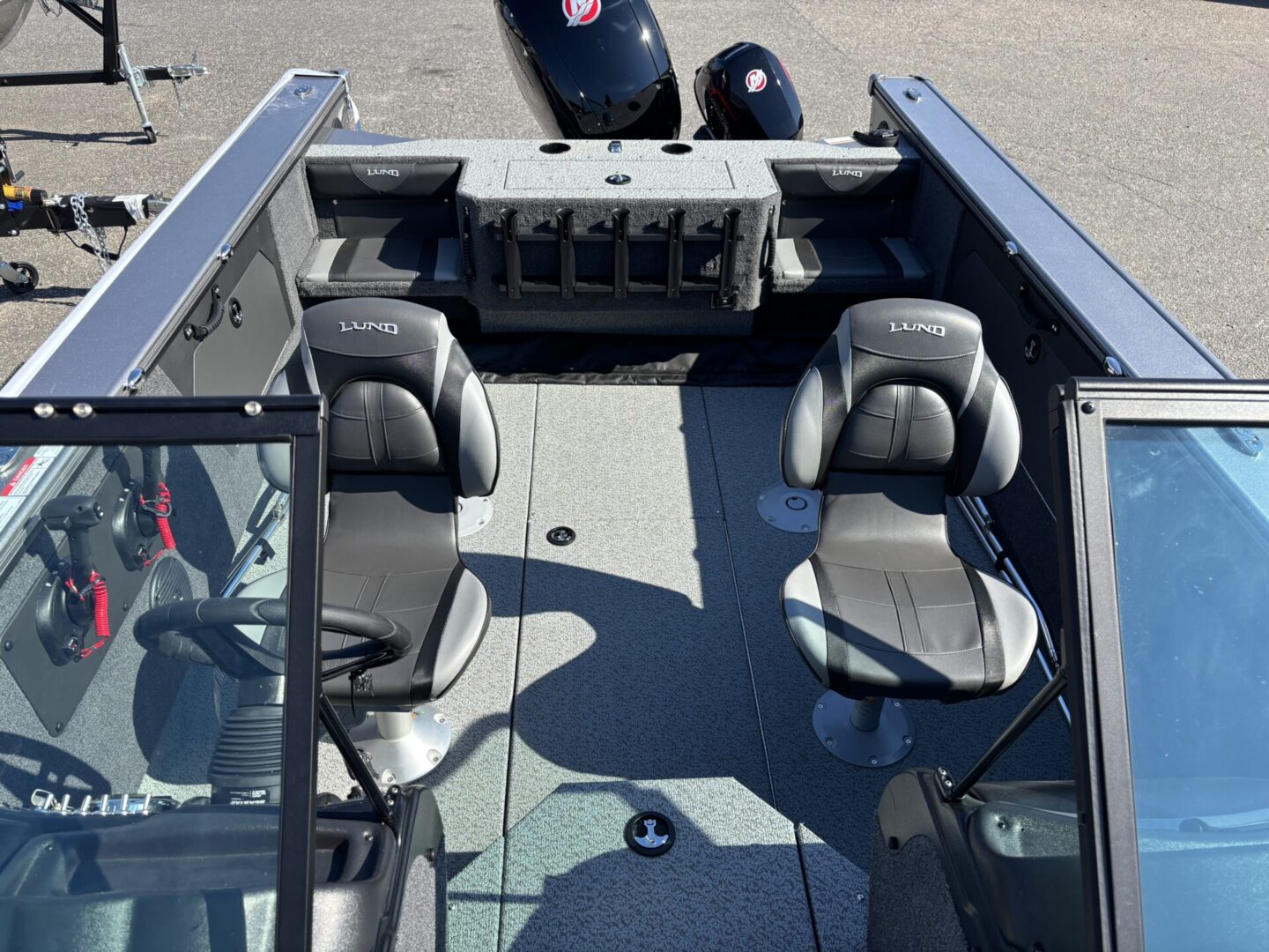 Interior of a small fishing boat with seats and a motor.