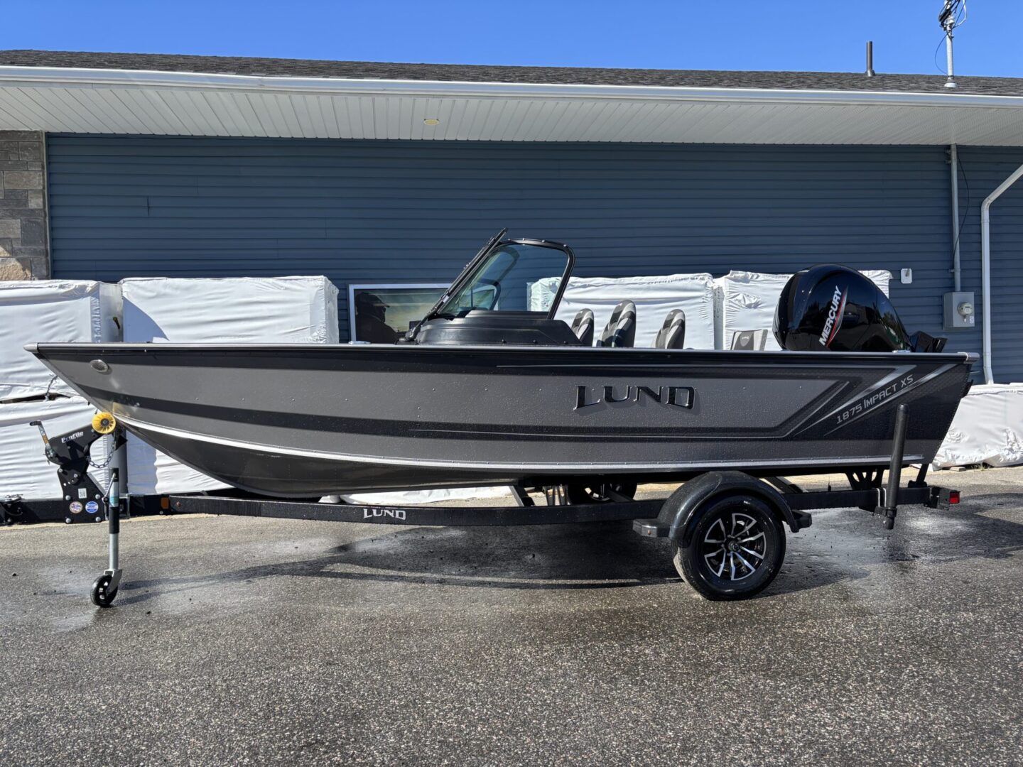 A sleek black and silver Lund fishing boat on a trailer.