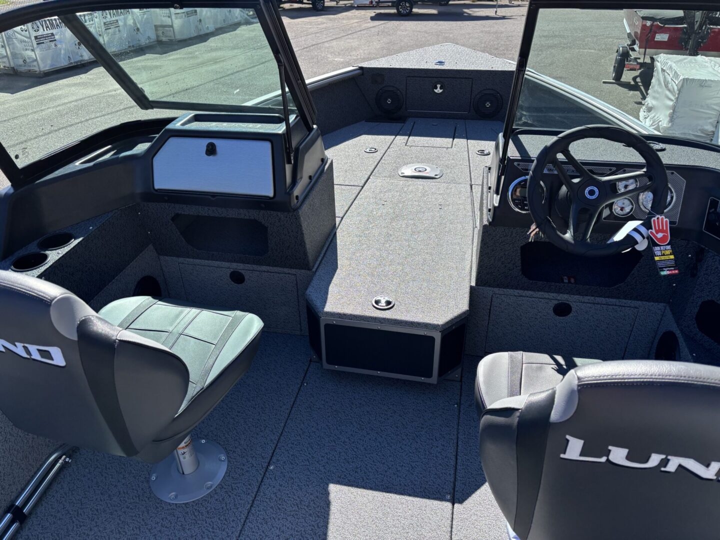 Interior view of a boat cockpit with seats and a steering wheel.