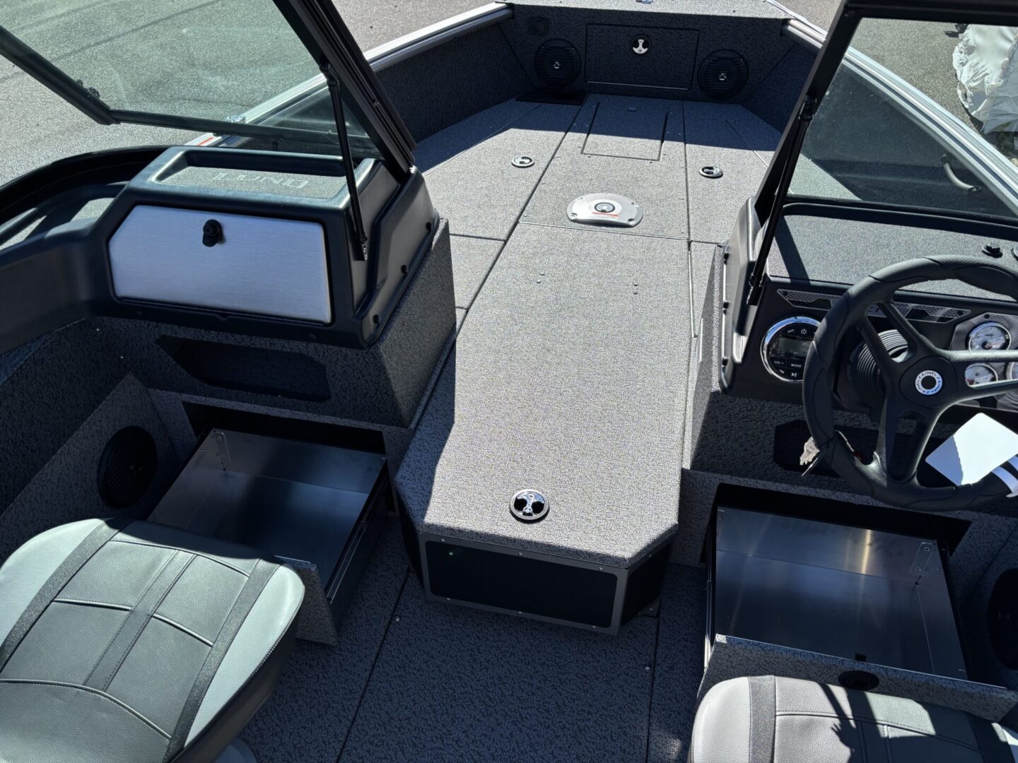 Interior view of a modern boat with seating and steering wheel.