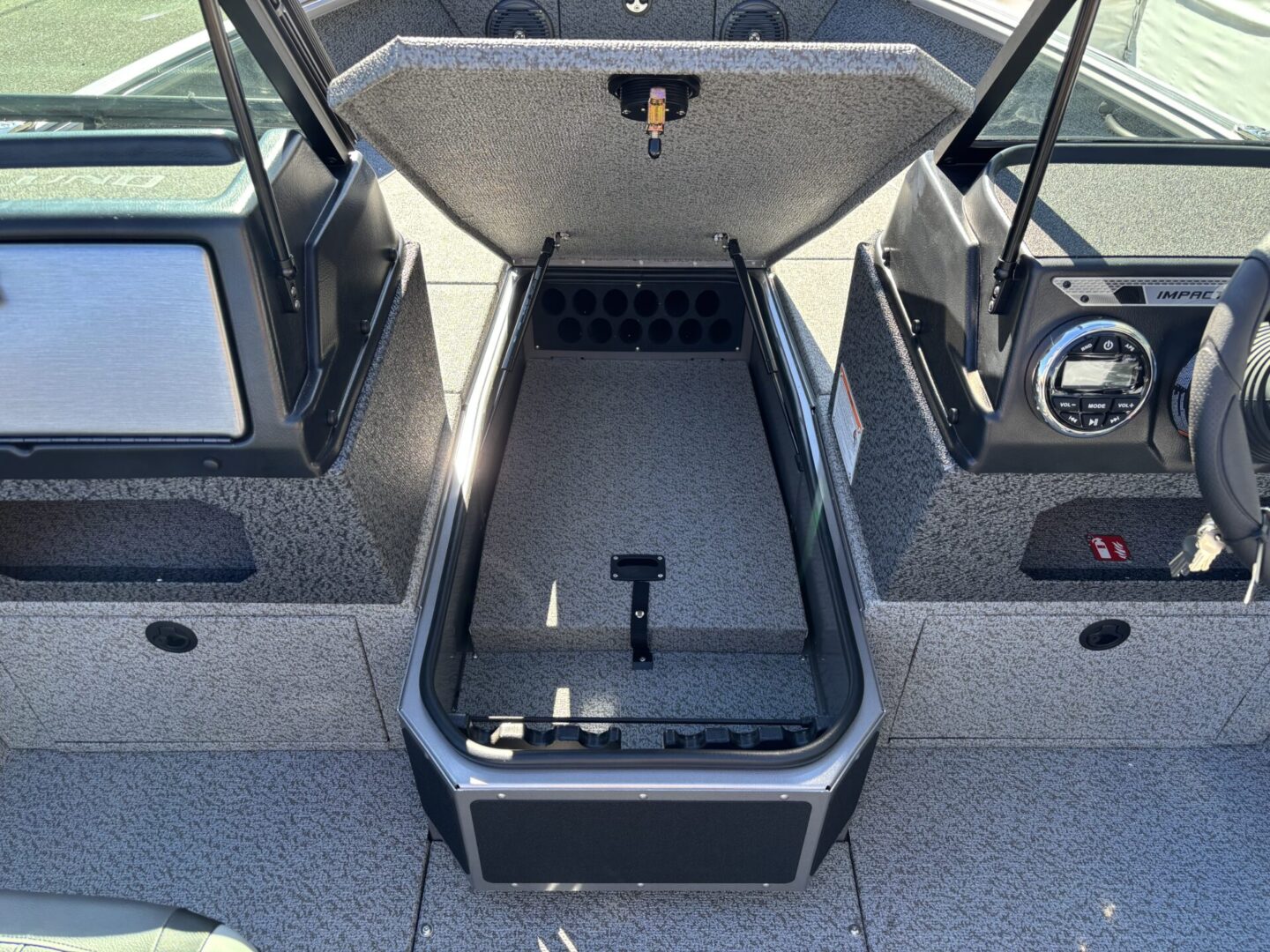 Open storage compartment on a boat with carpeted interior.