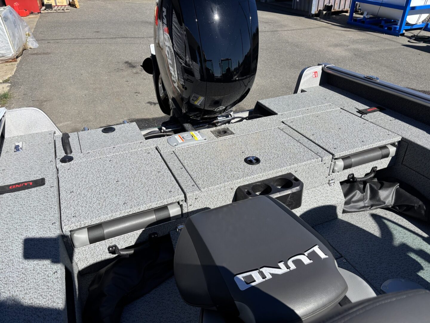 Boat motor and Lynx branded seat on a docked boat.