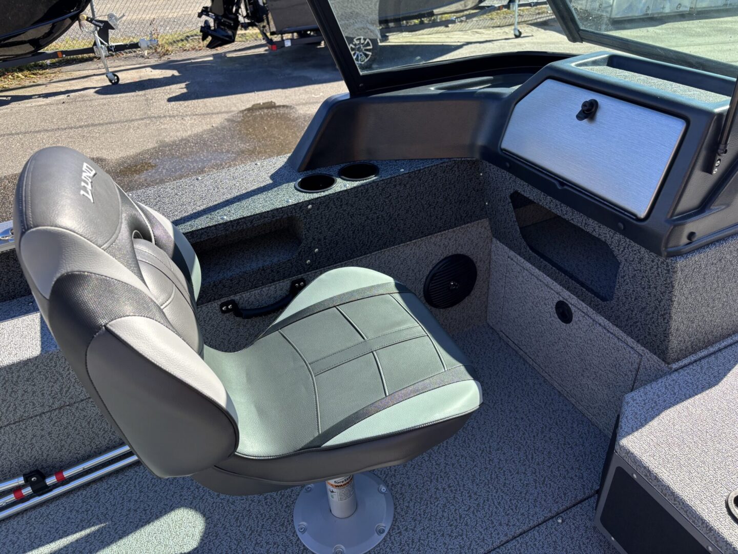 Interior of a boat showing a single seat and control panel.