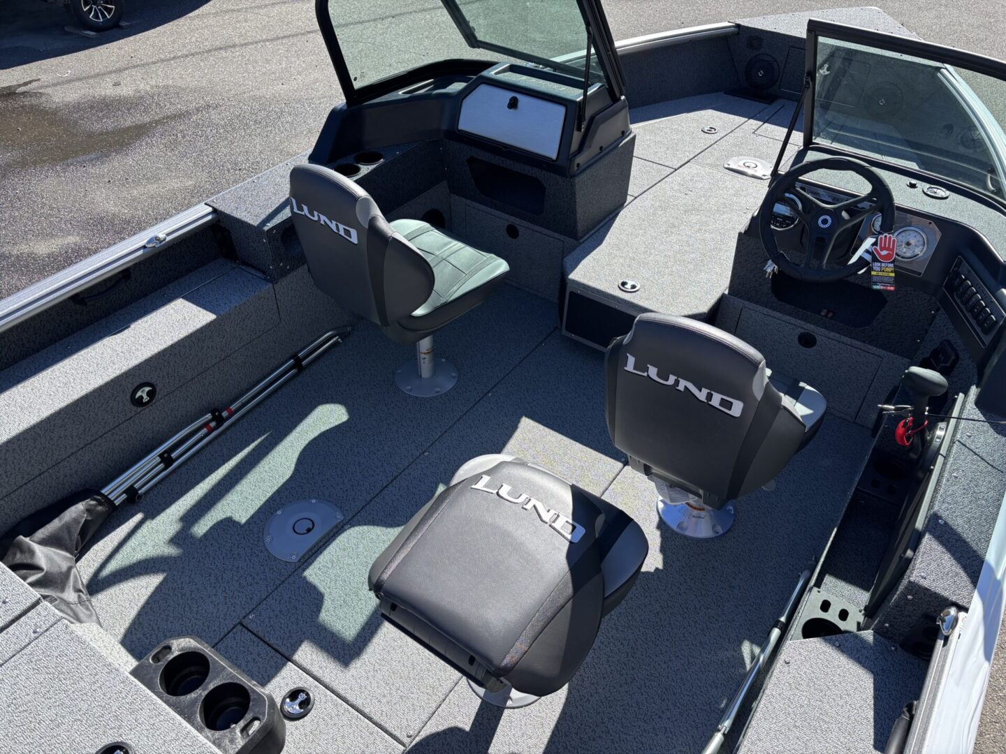 Interior view of a fishing boat with cushioned seats and steering console.