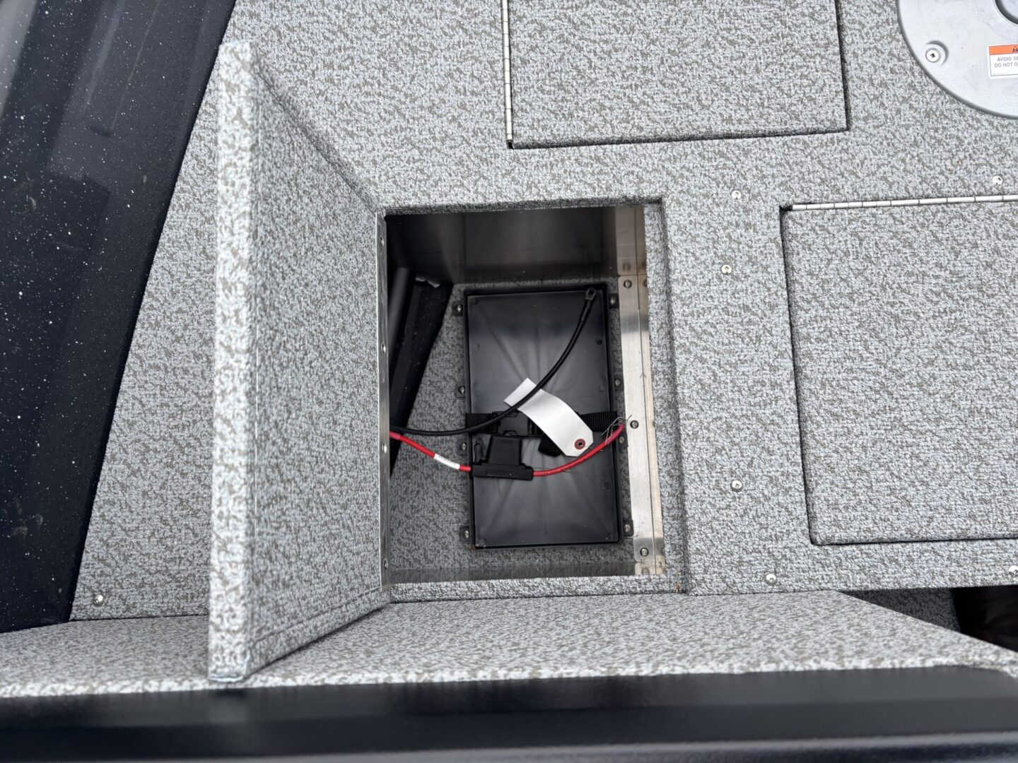 Open panel revealing cables and connectors inside a granite surface.