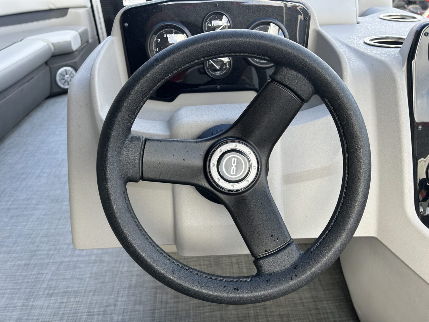 Black boat steering wheel close-up with gauges