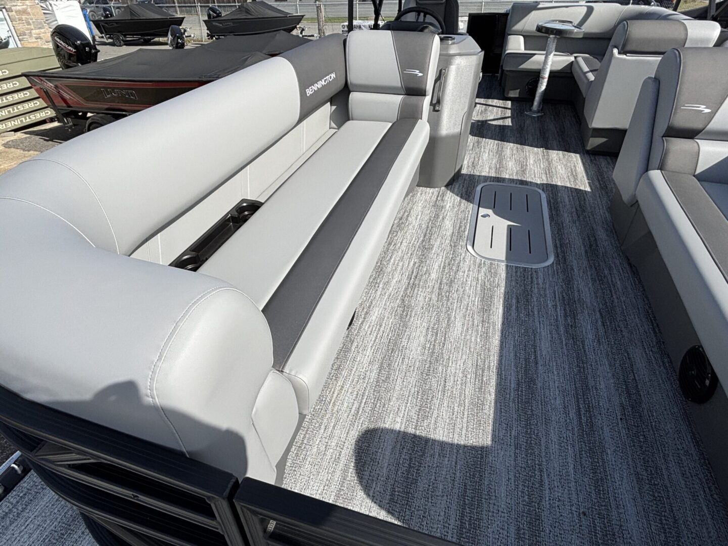 Modern boat seating with gray upholstery and wood-style flooring.