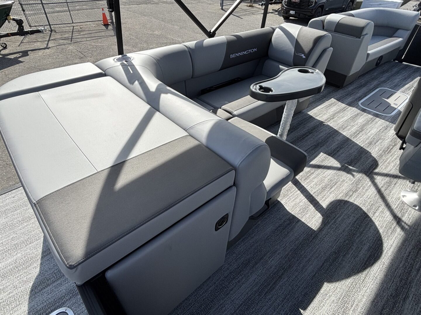 Modern boat seating area with gray cushions and a small table.