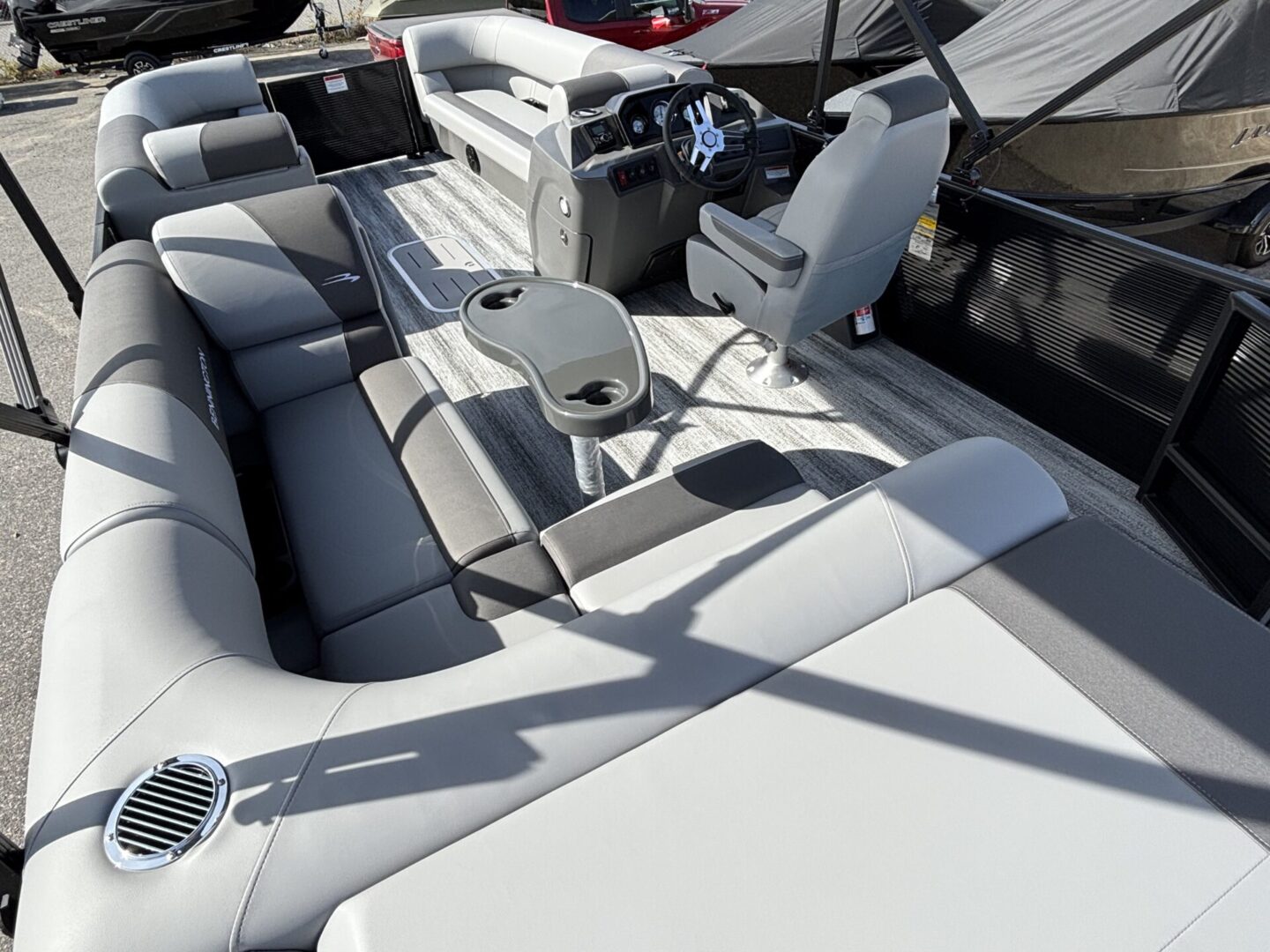 Spacious boat interior with white and gray cushioned seating.