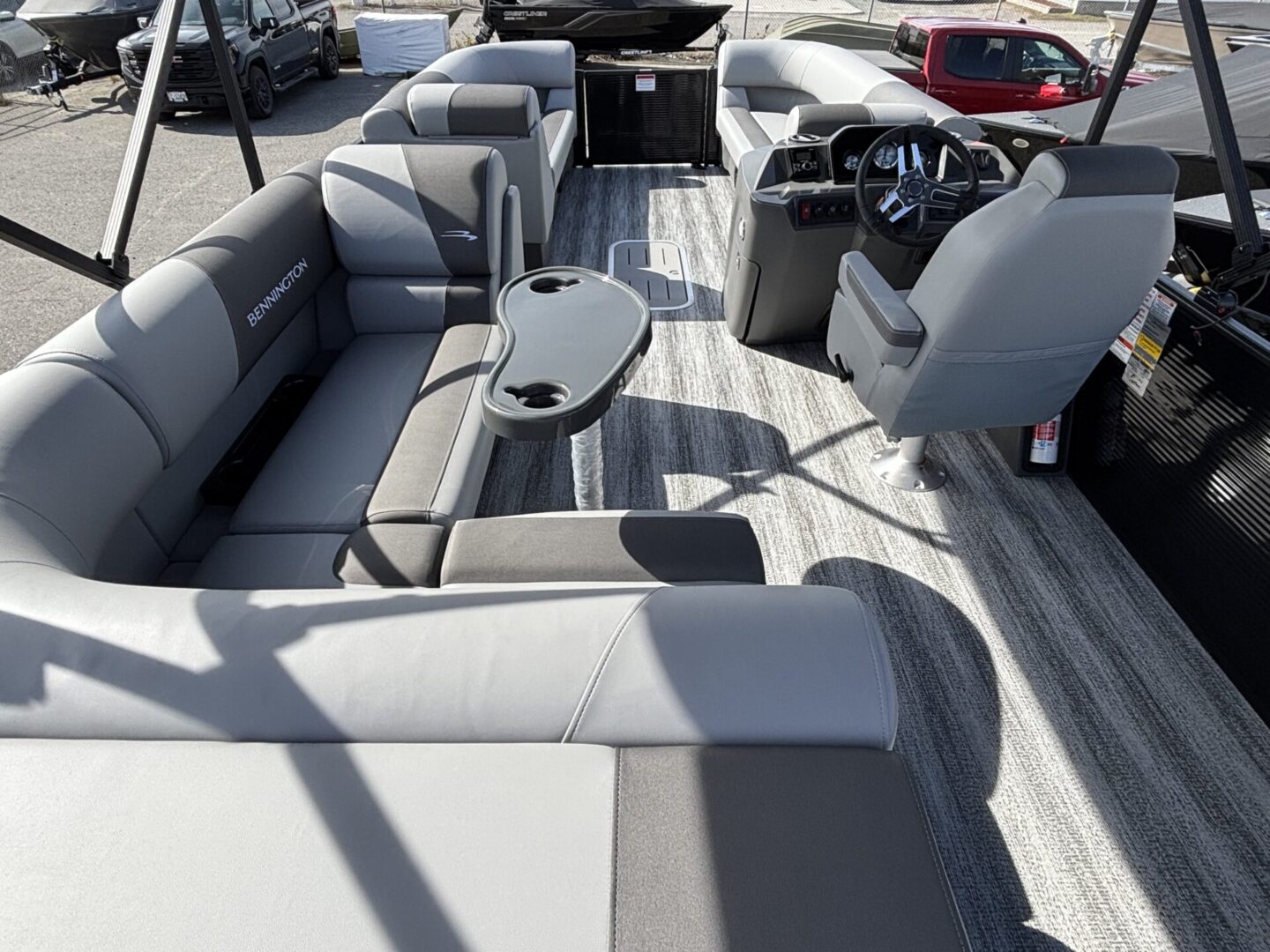 Luxurious pontoon boat seating area with sleek gray cushions and a small table.