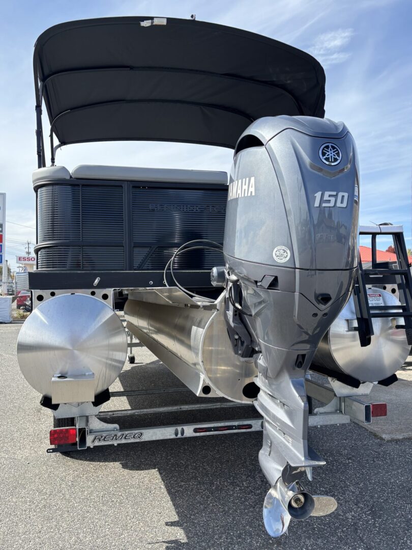 Silver 150 HP outboard motor on a boat in a marina.