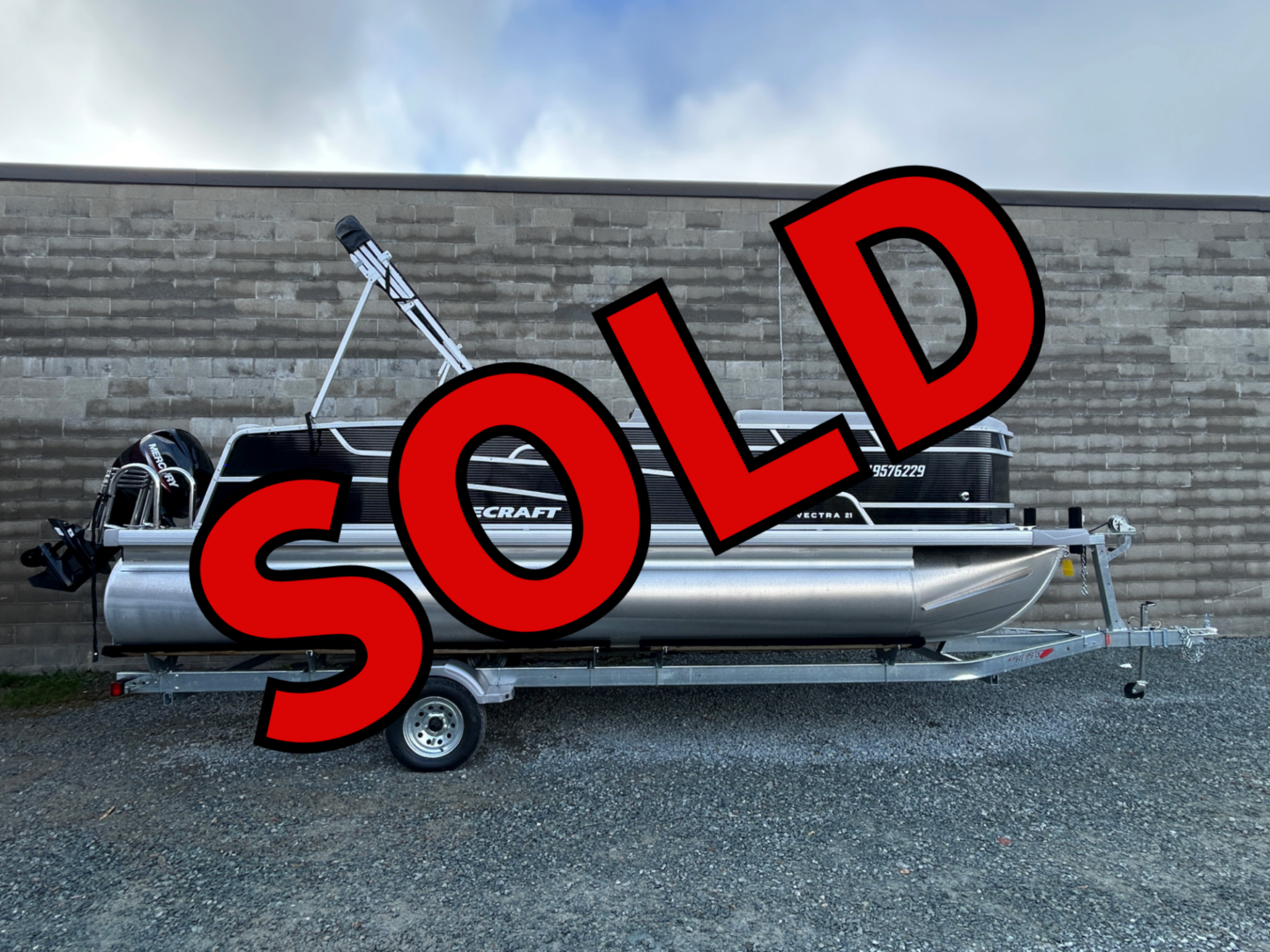 Pontoon boat on trailer with SOLD graphic