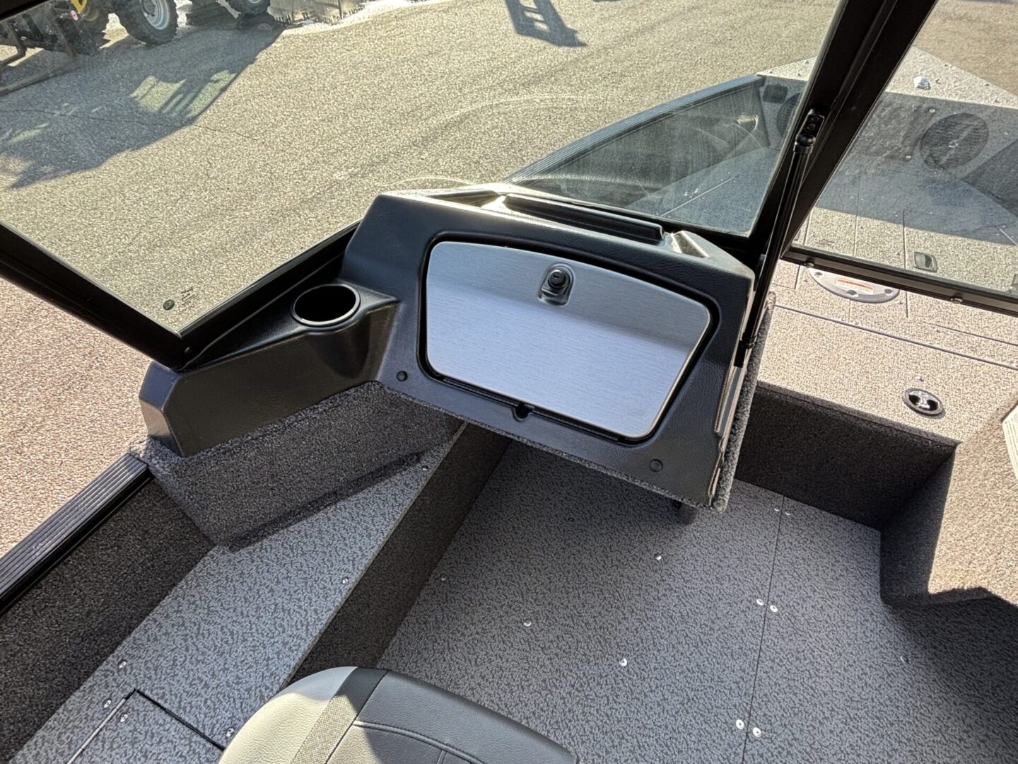 Boat dashboard with storage compartment and cup holder.