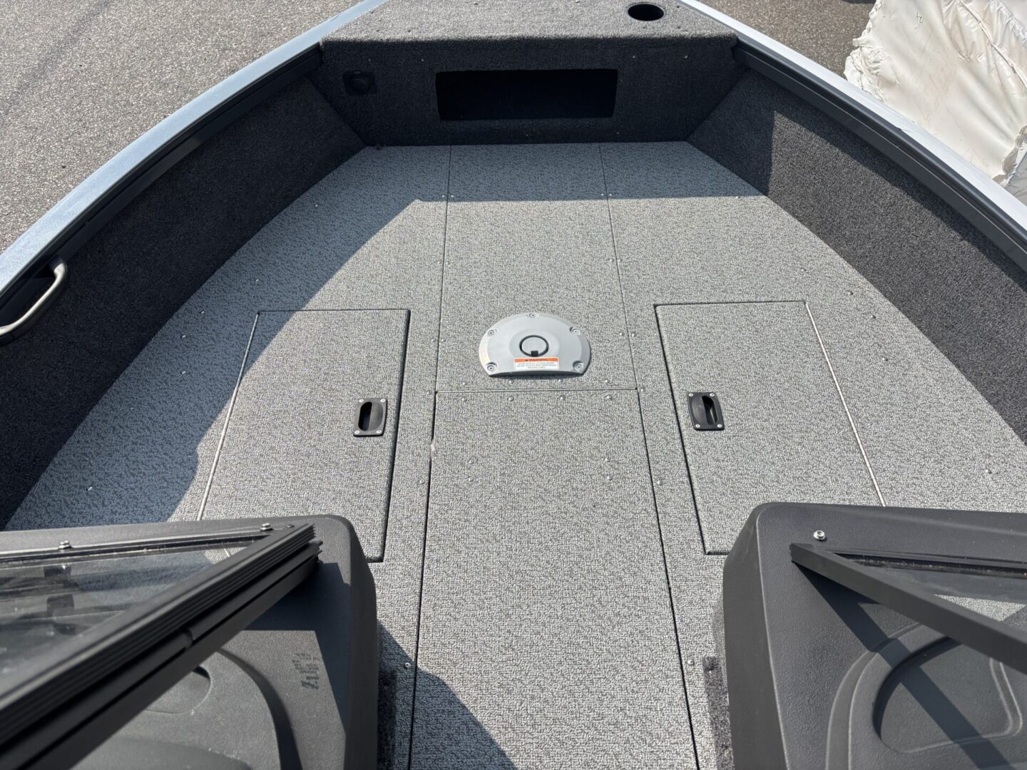 Front deck of a small fishing boat with storage compartments.